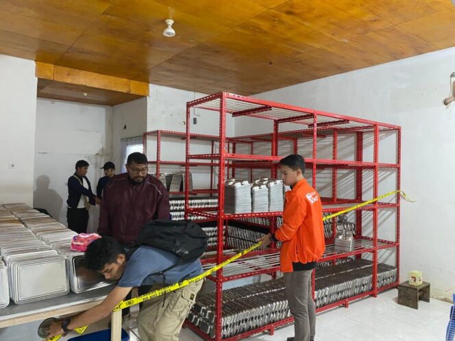 
					Polisi memasang garis police line untuk mengamankan barang bukti di dapur MBG penyebab keracunan massal di Banggai Kepulauan (Foto : Humas Polres Bangkep)