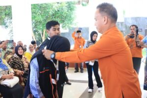 Kepala BPS Banggai Laut Ahmad,S.Sos memasang tanda pengenal dan rompi kepada perwakilan petugas sensus ekonomi (Foto : Ist)