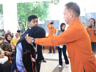 Kepala BPS Banggai Laut Ahmad,S.Sos memasang tanda pengenal dan rompi kepada perwakilan petugas sensus ekonomi (Foto : Ist)