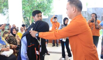 Kepala BPS Banggai Laut Ahmad,S.Sos memasang tanda pengenal dan rompi kepada perwakilan petugas sensus ekonomi (Foto : Ist)