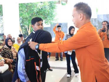Kepala BPS Banggai Laut Ahmad,S.Sos memasang tanda pengenal dan rompi kepada perwakilan petugas sensus ekonomi (Foto : Ist)
