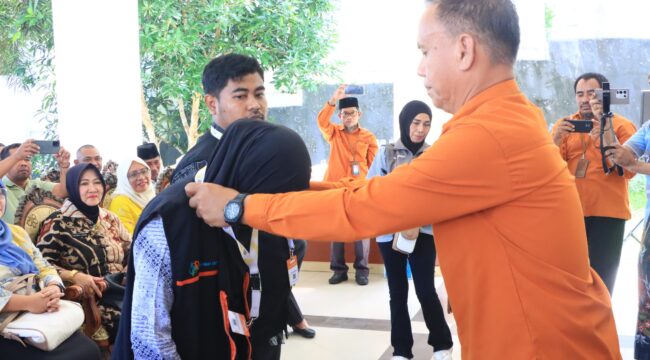 Kepala BPS Banggai Laut Ahmad,S.Sos memasang tanda pengenal dan rompi kepada perwakilan petugas sensus ekonomi (Foto : Ist)
